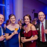 Guests posing, holding drinks in the Laker Lounge